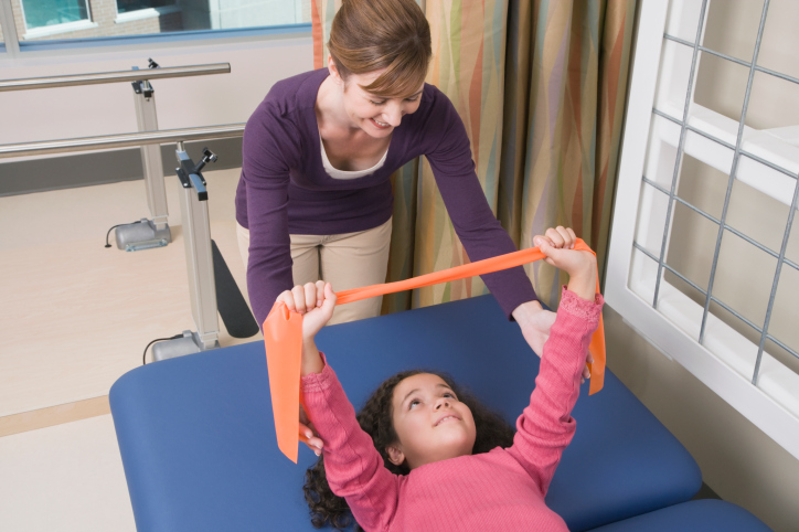 Physical Therapist Helping Girl in Center